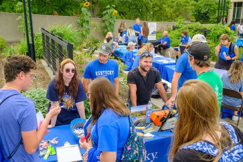 Students meet with student org representatives at an outdoor involvement fair.