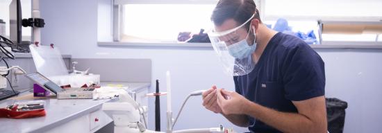 Dentist looking down and practicing on a fake patient