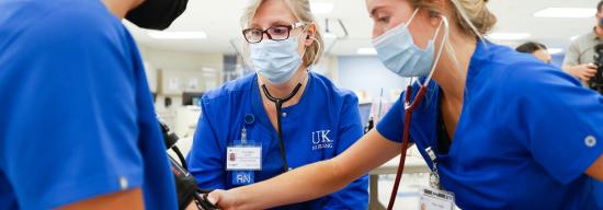 Two female nursing students practicing with their female professor