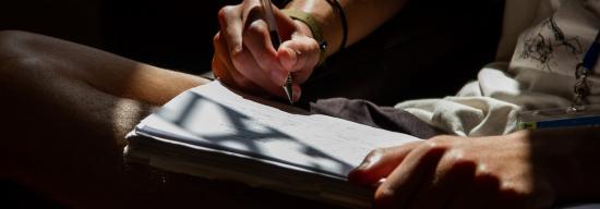 Person writing on a notepad
