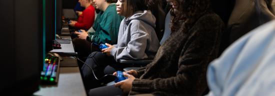 Row of people playing video games on computers