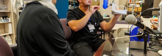 Female and male student in black lab coats conducting a medical inspection