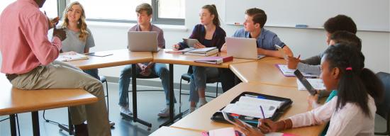 Professor lecturing students sitting at a round table
