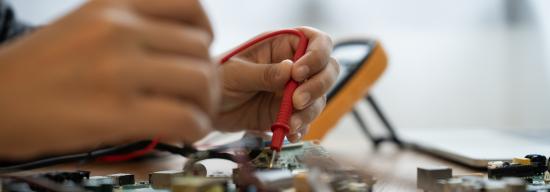 Students' hands testing out electrical circuits