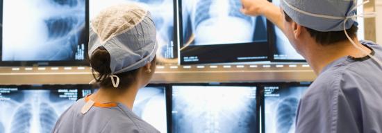 Two doctors observing X-rays of a persons torso