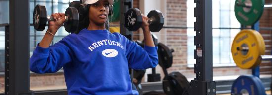 Female lifting weights in a gym.