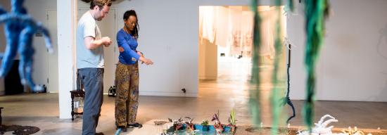 Two men observing art pieces in a room
