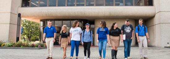 Group of students laughing while leaving a classroom building