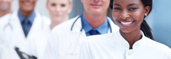 Group of clinicians smiling in white lab coats