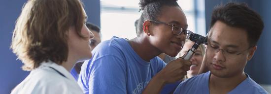 Female doctor giving a male an ear exam